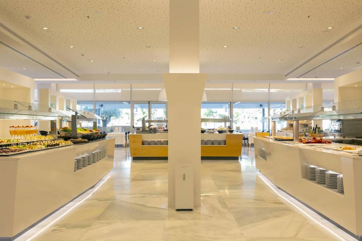 Buffet-Restaurant im Hipotels Gran Playa de Palma mit einer Vielzahl von Speisen und gedeckten Tischen.