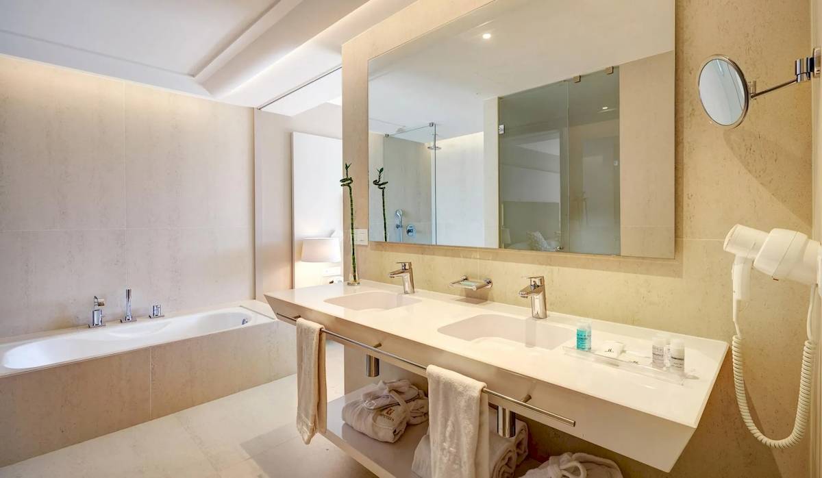 Hotelbadezimmer mit Doppelwaschbecken, Spiegel und Badewanne