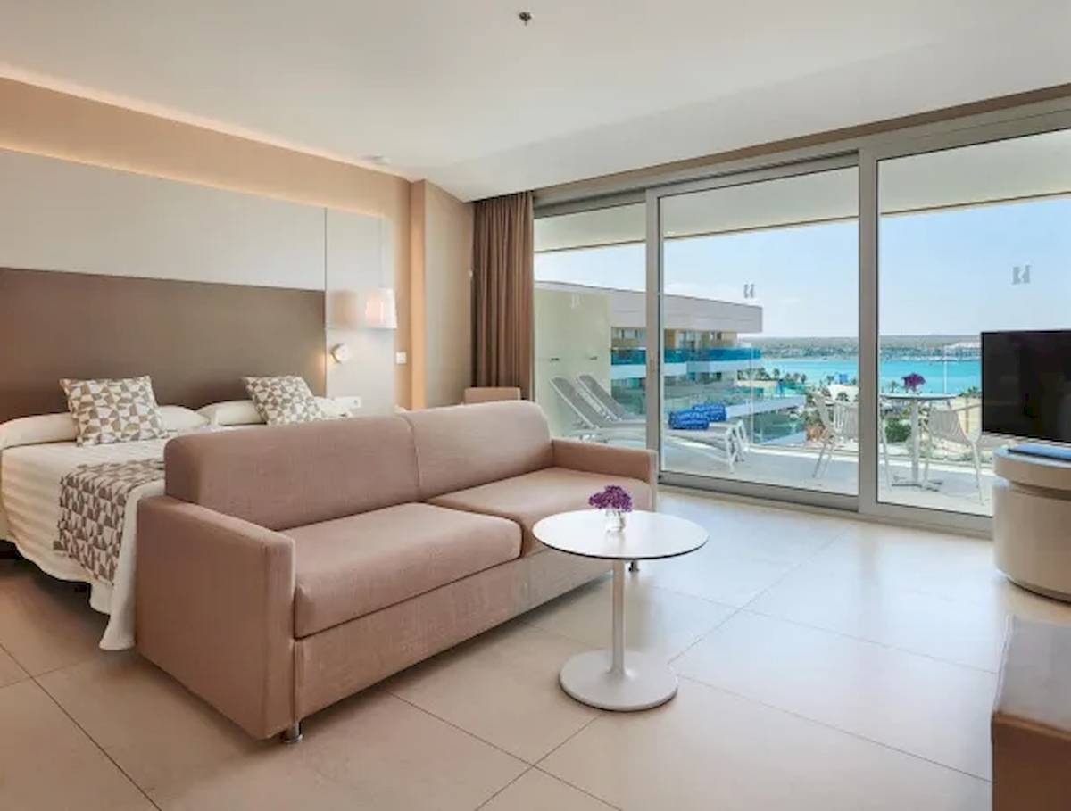 Zimmer im Hipotels Gran Playa de Palma mit Blick auf das Meer und eine Terrasse mit Möbeln.