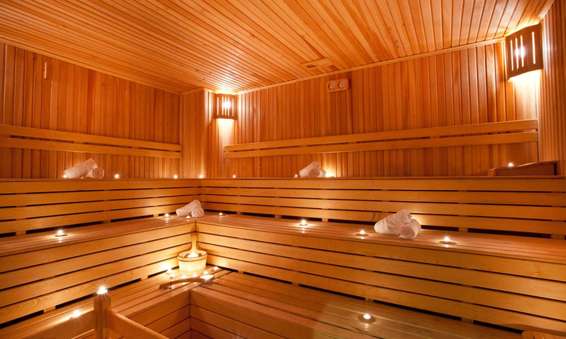 Innenansicht der Sauna im Sherwood Dreams Resort mit Holzbänken und Kerzenlicht