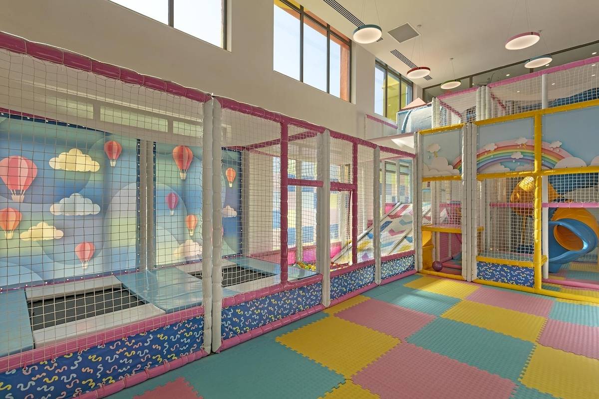 Kinderspielplatz im Cullinan Belek Hotel mit bunten Farben, Trampolinbereich und Kletterwand.