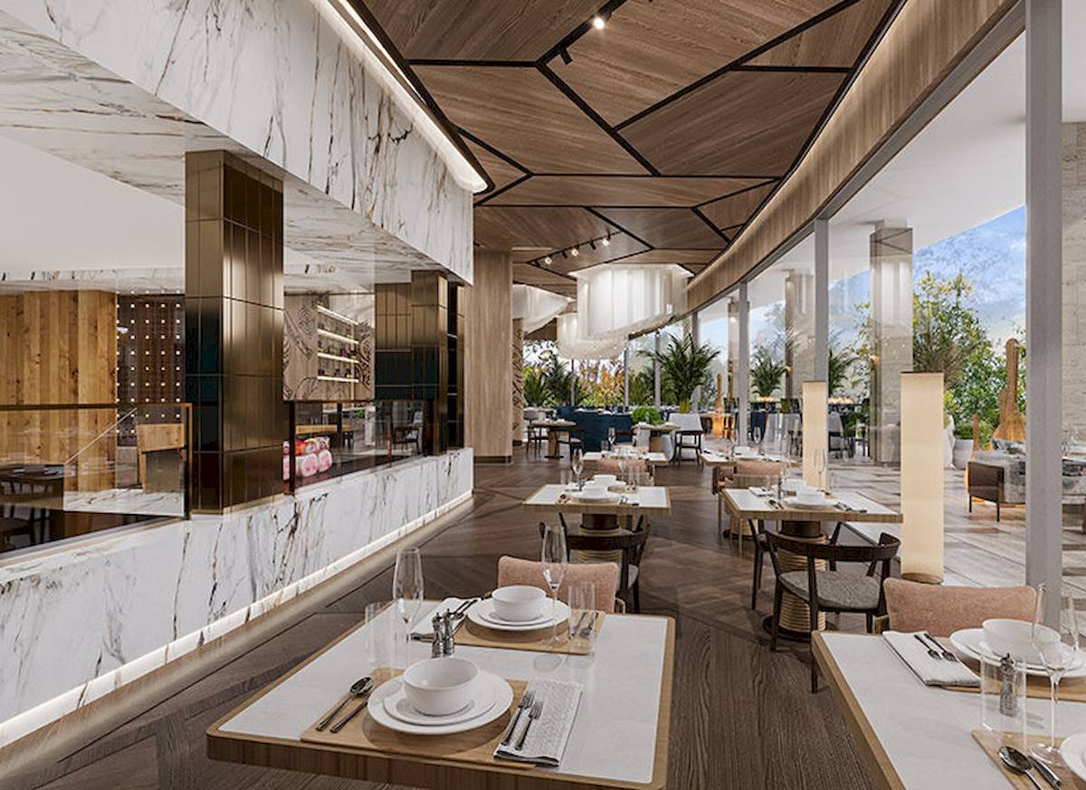 Innenansicht des Restaurants von Gloria Serenity Resort mit Holzboden, Marmorwänden und hängenden Leuchten.