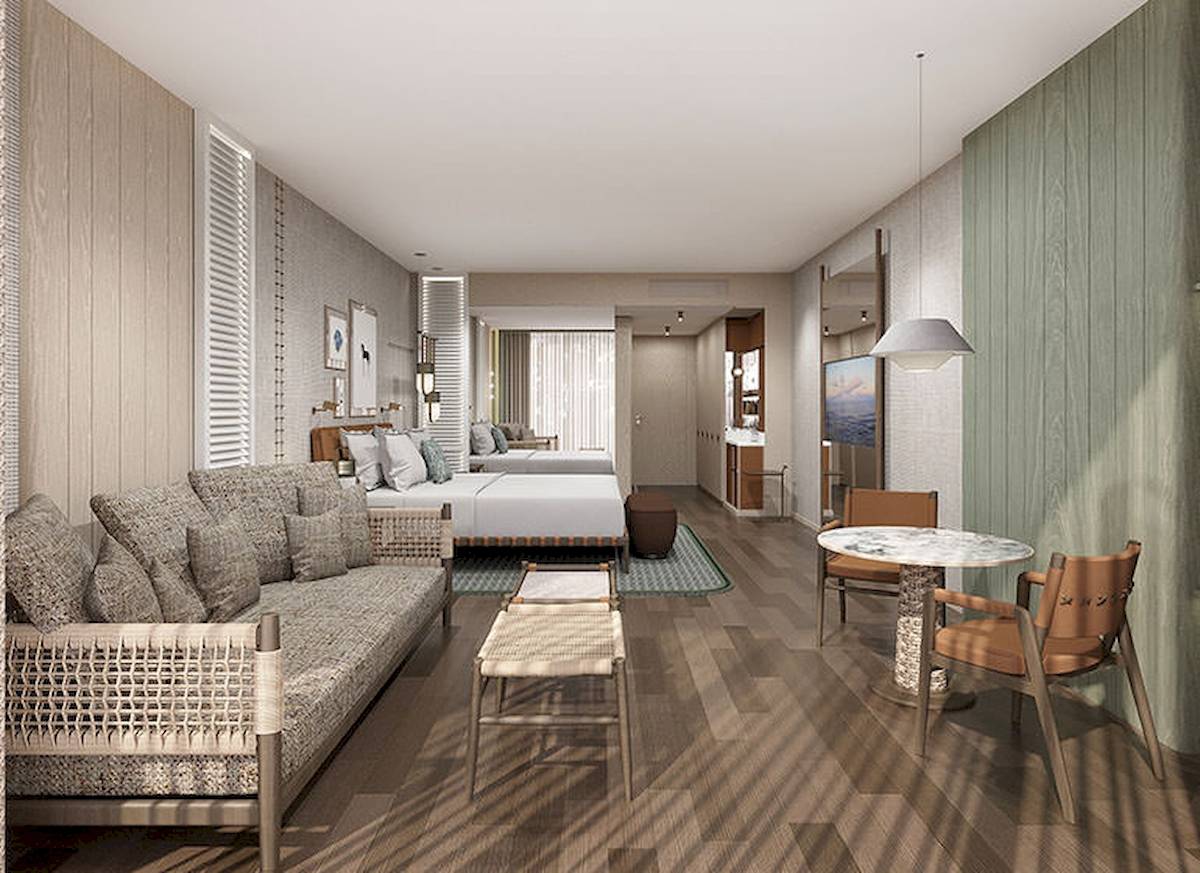 Innenansicht einer Suite im Gloria Serenity Resort mit Wohnzimmer, Schlafbereich und Tisch.