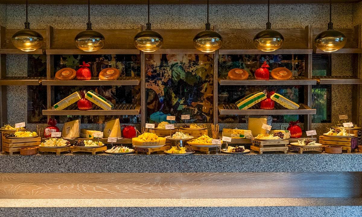 Buffet-Tisch im Gloria Serenity Resort mit verschiedenen Käsesorten und Früchten.