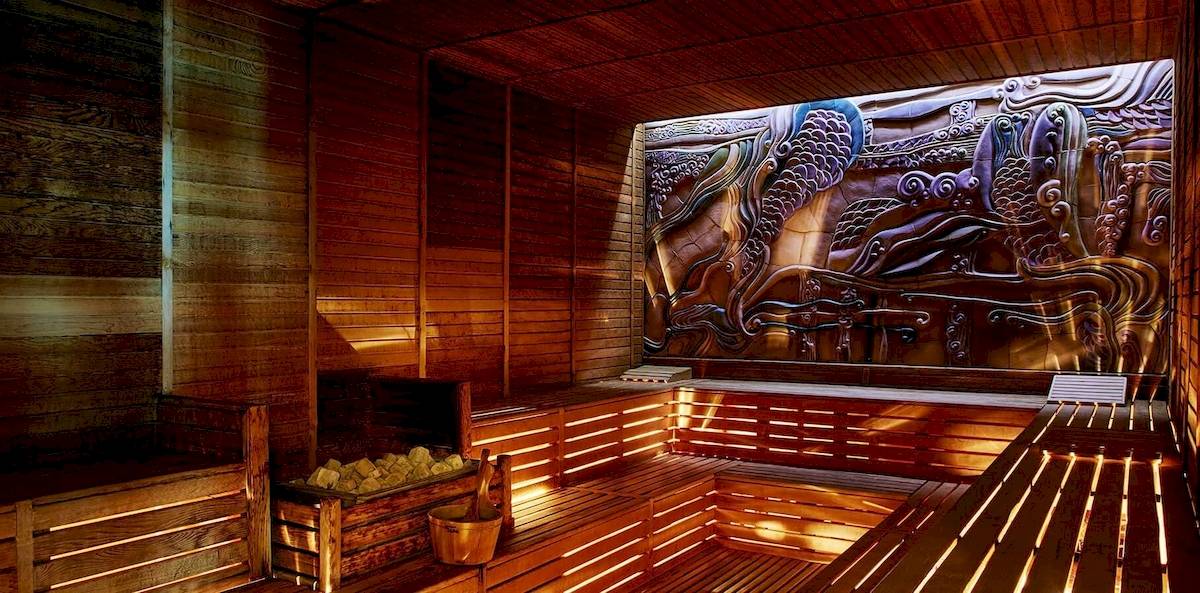 Innenansicht der Sauna im Gloria Golf Resort mit Holzwänden und einem großen Wandbild.