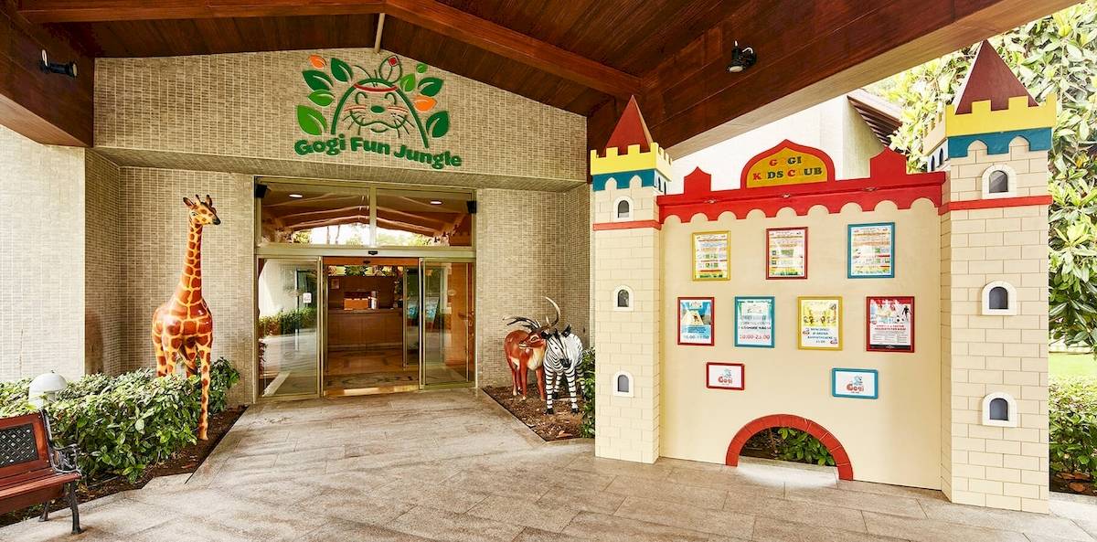 Eingang zum Gogi Fun Jungle im Gloria Golf Resort mit bunten Gebäuden und Tierfiguren.