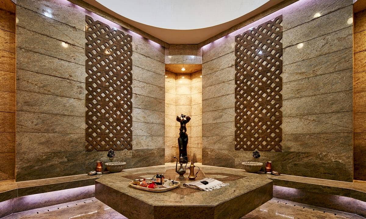 Saunabereich im Gloria Golf Resort mit marmornen Wänden und einer zentralen Figur.