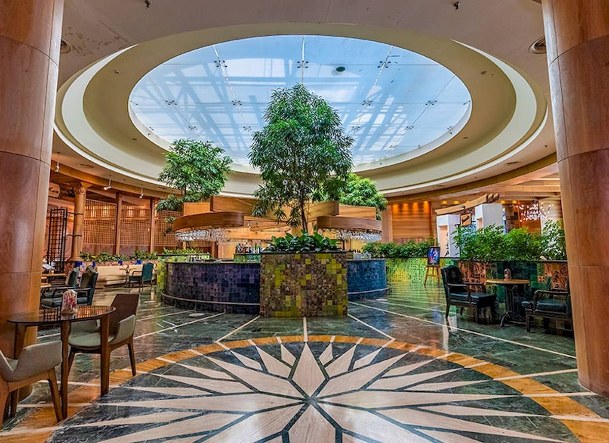 Hotelfoyer mit einer großen Kuppel und Pflanzen in der Mitte des Raumes.