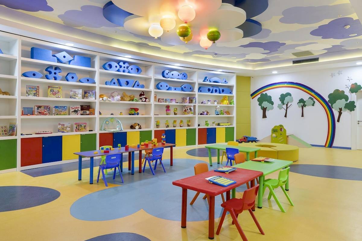 Farbiges Kinderzimmer im Titanic Luxury Collection Bodrum Hotel mit bunten Möbeln, Spielzeug und einer Regenbogenwand.