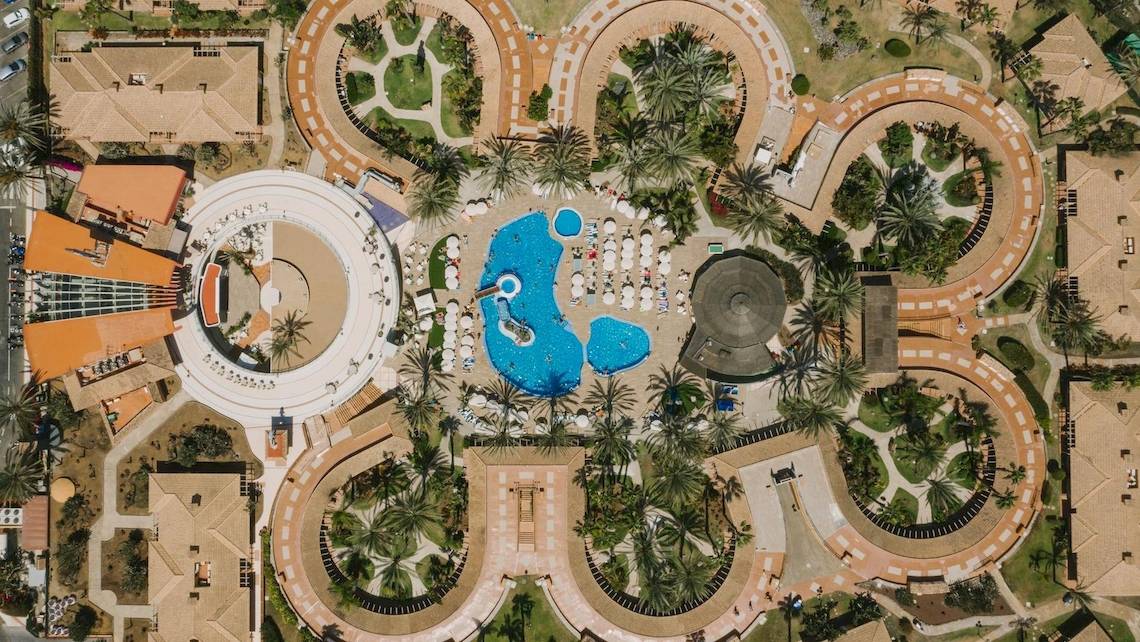 Luftaufnahme des Suites & Villas By Dunas Resorts, zeigt das blaue Schwimmbad und die umliegenden Gebäude.