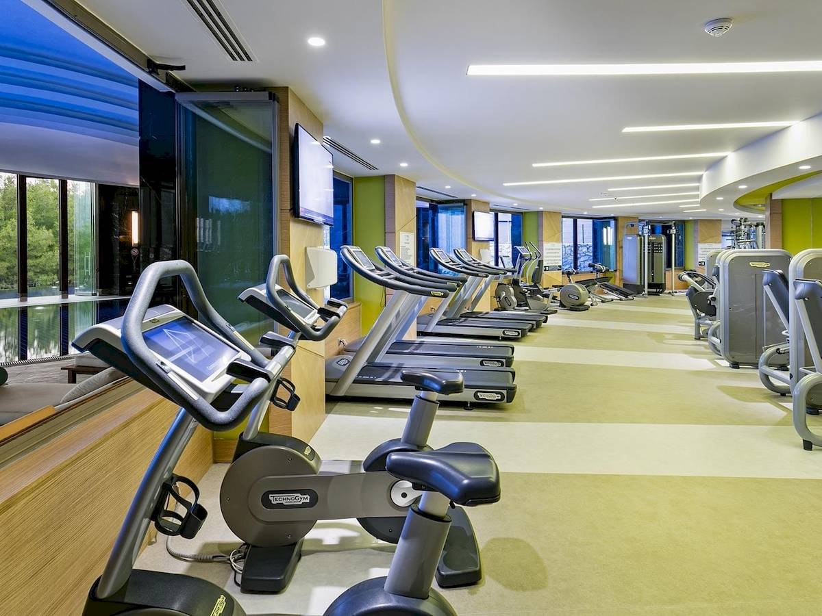 Fitnessstudio im Titanic Luxury Collection Bodrum mit mehreren Laufbändern und Fitnessgeräten.