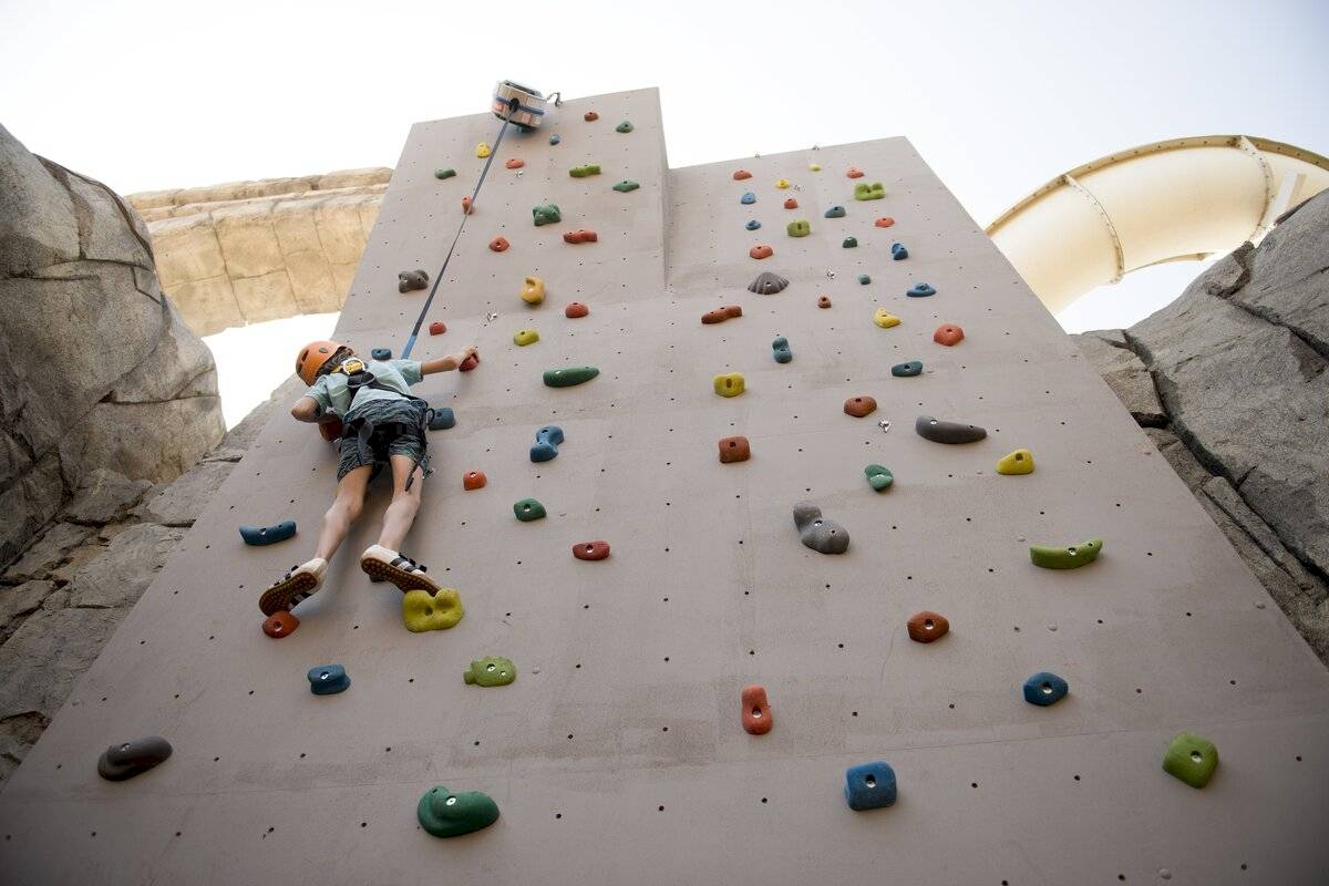Junge klettert an einer Wand mit bunten Griffen im Xanadu Resort Hotel