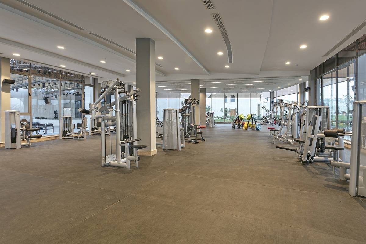 Fitnesscenter im Xanadu Makadi Bay Hotel mit vielen Geräten und großen Fenstern.
