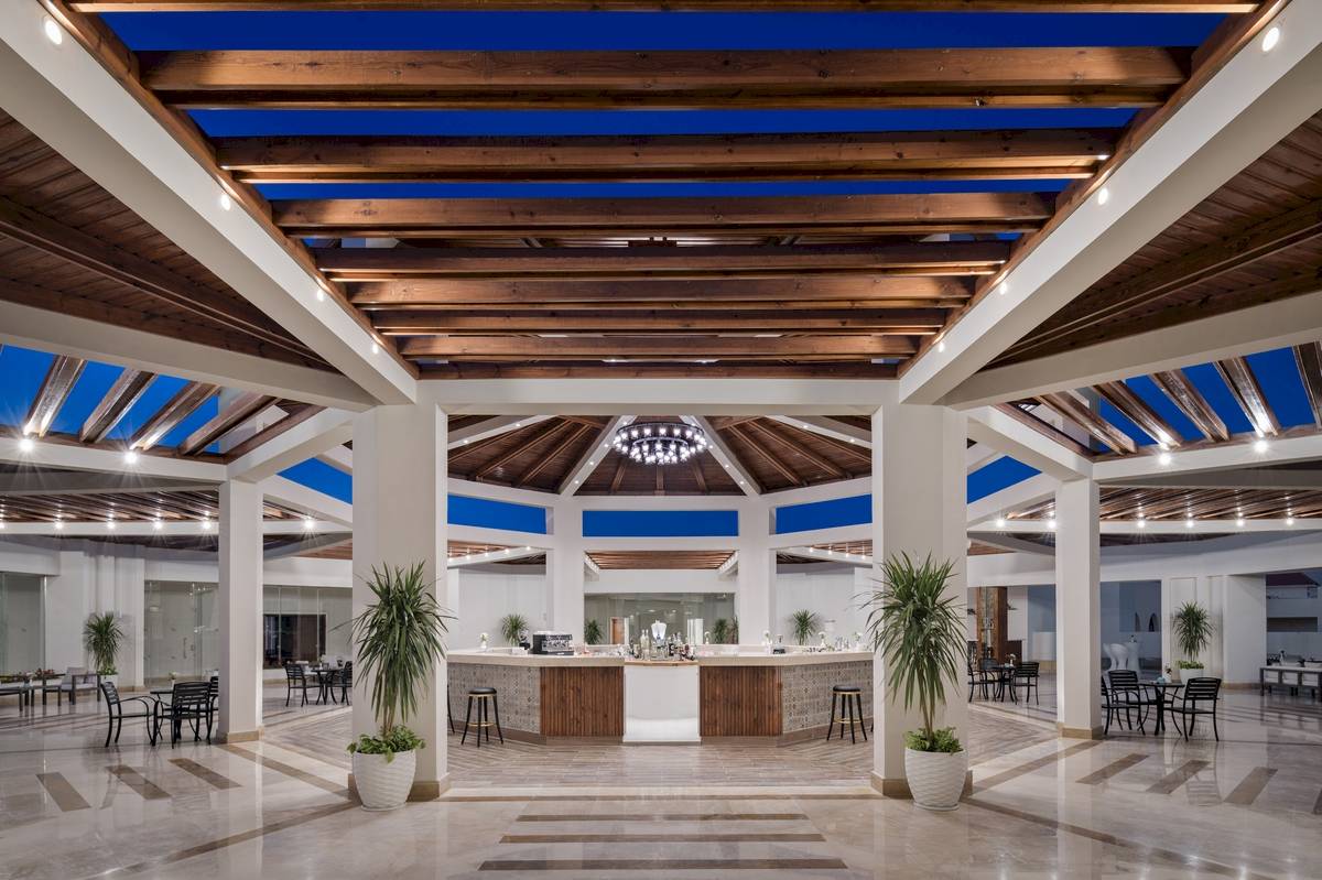 Innenansicht der Lobby des Xanadu Makadi Bay Hotels mit Holzdecken und Tischen.