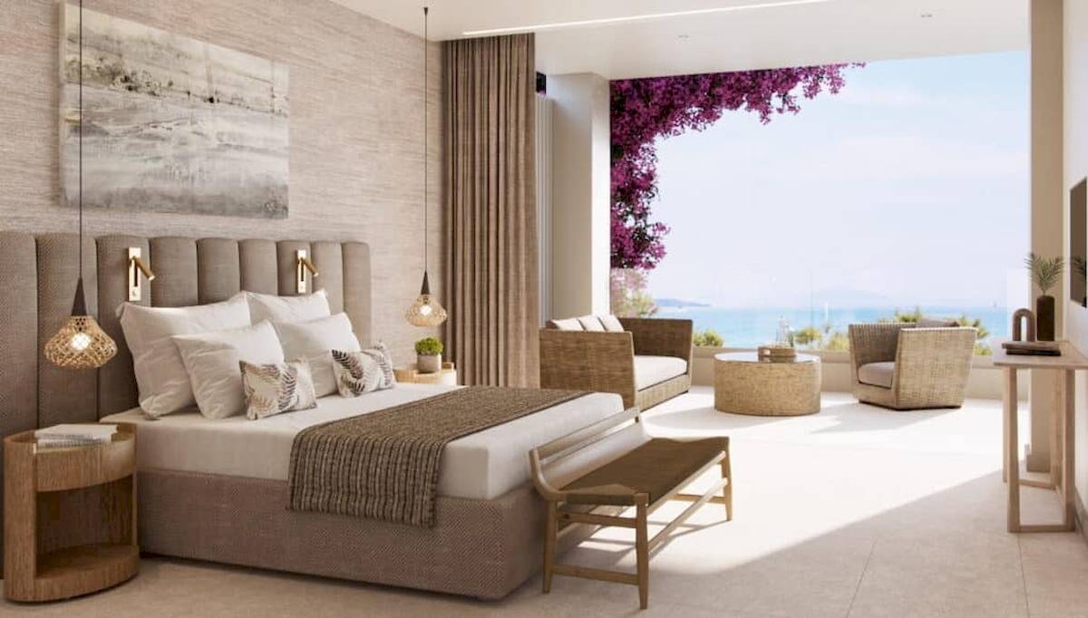 Schlafzimmer im Ikos Odisia Hotel mit Blick auf das Meer und die Küste.