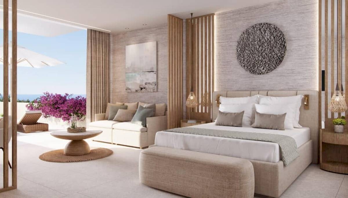 Hotelzimmer Interieur mit Bett, Couch und Blick auf das Meer im Ikos Odisia.