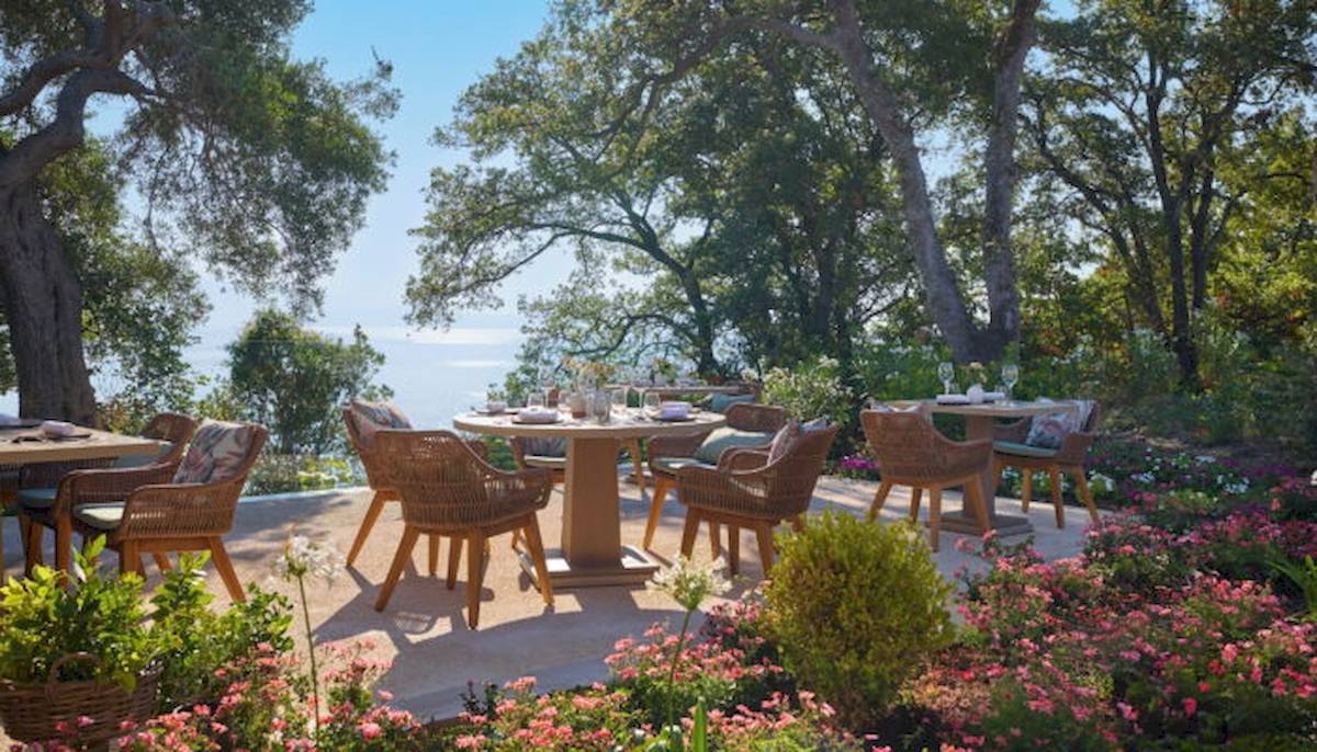 Gartensitzplatze mit Tischen und Stühlen im Freien im Ikos Odisia Hotel