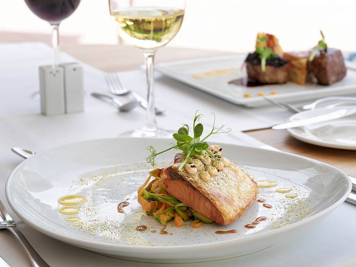 Essen im Restaurant des H10 Blue Mar Boutique Hotels mit Fischgericht und Beilagen.