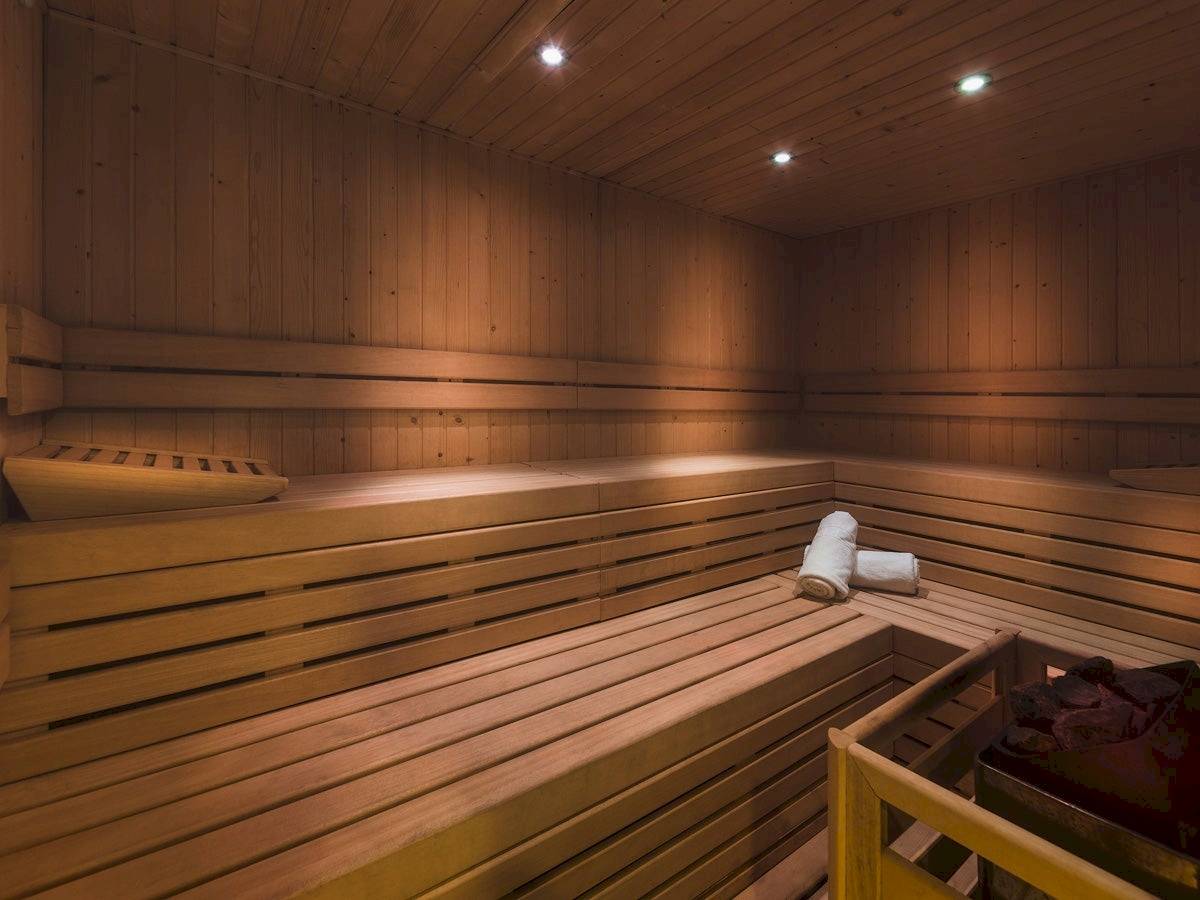Sauna im H10 Casa del Mar Hotel mit Holzbänken und Handtüchern.