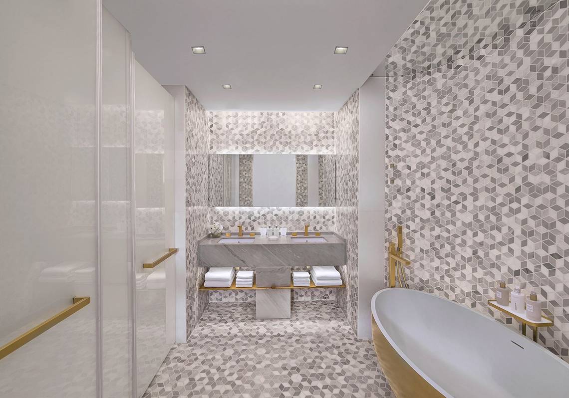 Das Badezimmer im FIVE Palm Jumeirah Hotel mit geometrischen Kacheln und einer Badewanne.