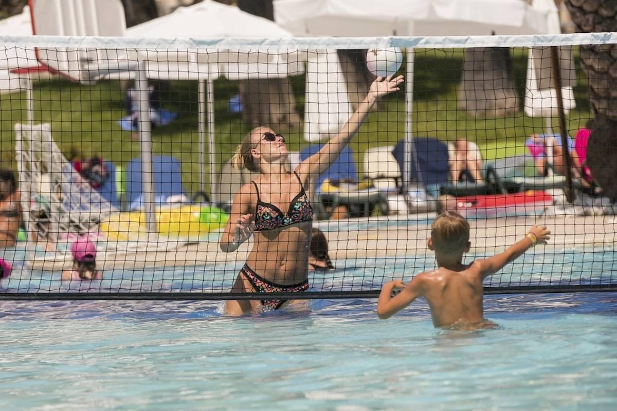 Eine Frau und ein Junge spielen Volleyball im Pool des Monachus Family Resort Sorgun.