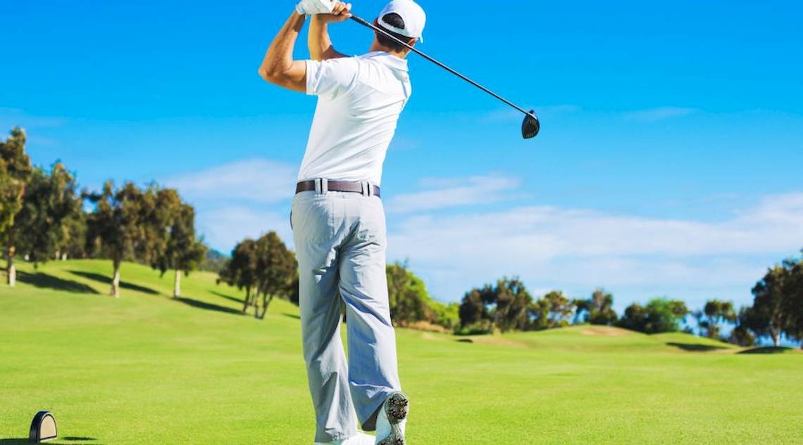 Golfspieler beim Schwung auf einem Golfplatz im Freien.