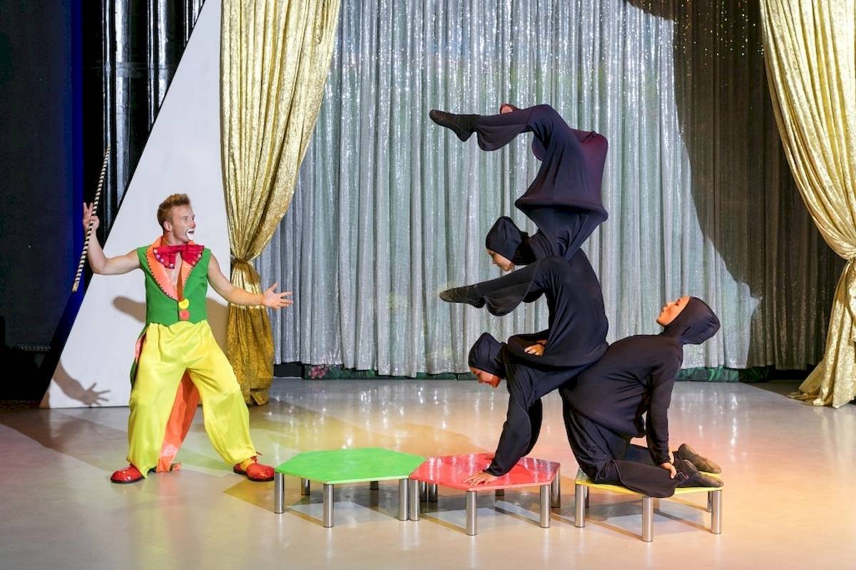 Artisten führen eine Show im Seven Seas Hotel Life auf, mit einem Mann in Clownkostüm und zwei Frauen in schwarzen Kostümen.