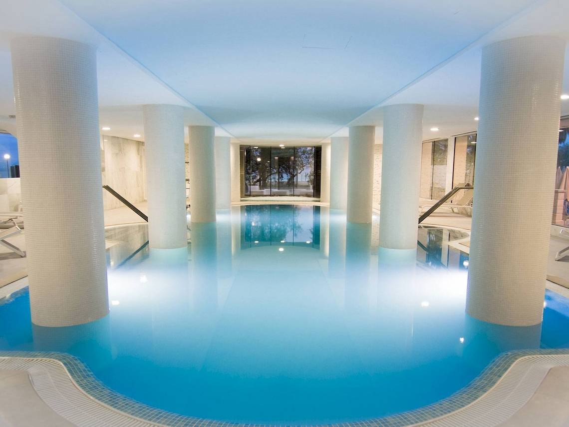 Innenpool des CM Castell de Mar Hotels mit blauem Wasser und weißen Säulen