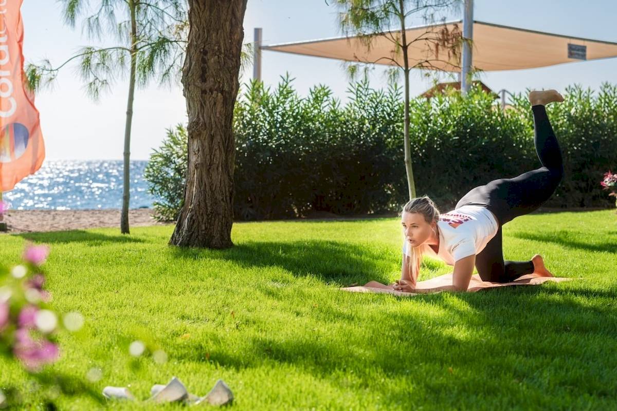 Eine Frau macht Yoga im Garten des Seven Seas Hotel Life.