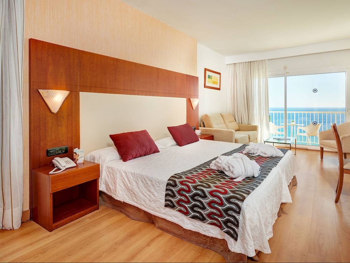 Zimmer im CM Castell de Mar Hotel mit Blick auf den Balkon und das Meer.
