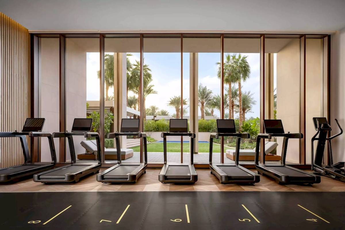 Fitnesscenter im Atlantis The Royal mit mehreren Laufbändern und Panoramafenstern.