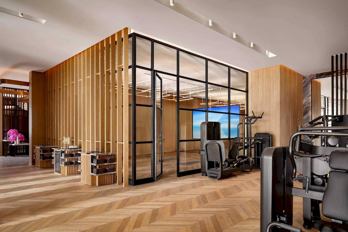 Fitnesscenter-Innenansicht von Atlantis The Royal mit Holzwänden und Glastüren.