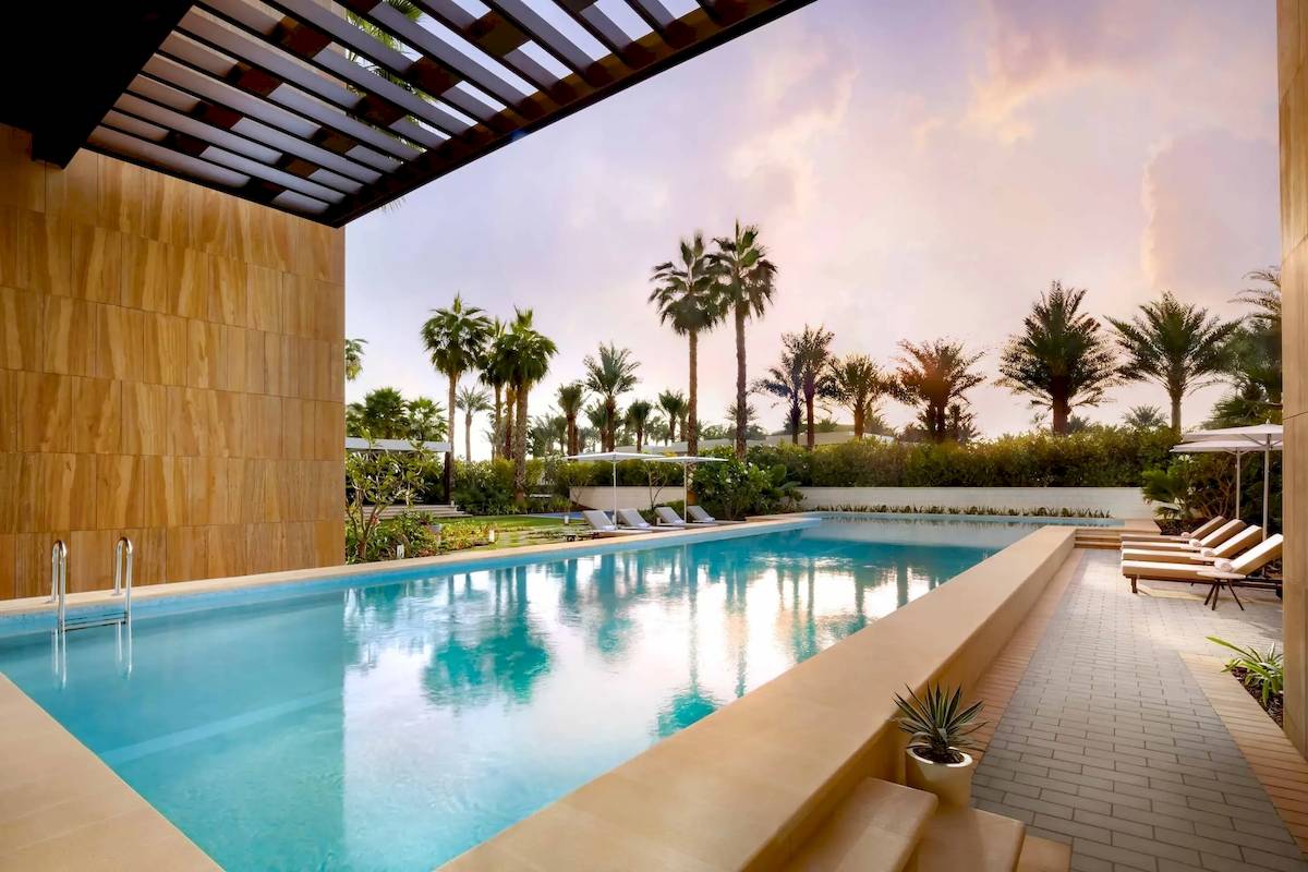 Außenpoolbereich des Atlantis The Royal Hotels mit Loungeliegen und Palmen