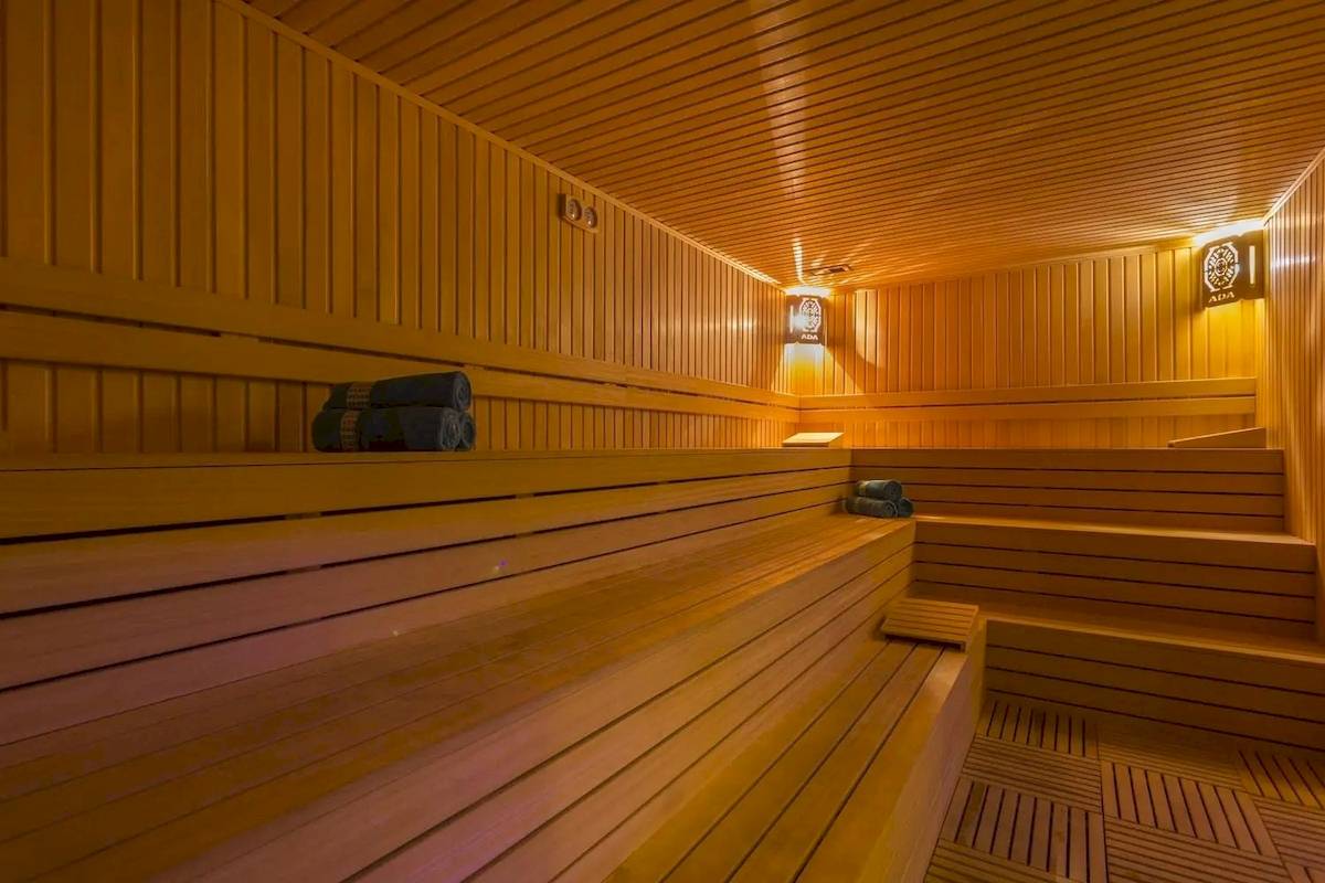 Innenansicht der Sauna im Eftalia Ocean Hotel mit Holzbänken und Deckenbeleuchtung.
