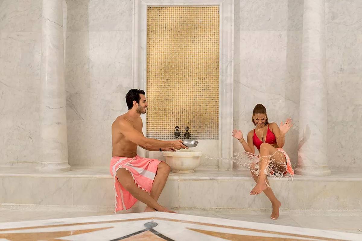 Ein Mann und eine Frau im Melas Resort Spa Bereich, der Mann in einem pinken Handtuch.
