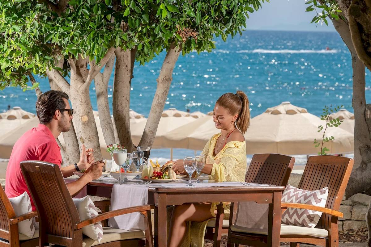 Ein Paar genießt ein Essen am Strand im Melas Resort.