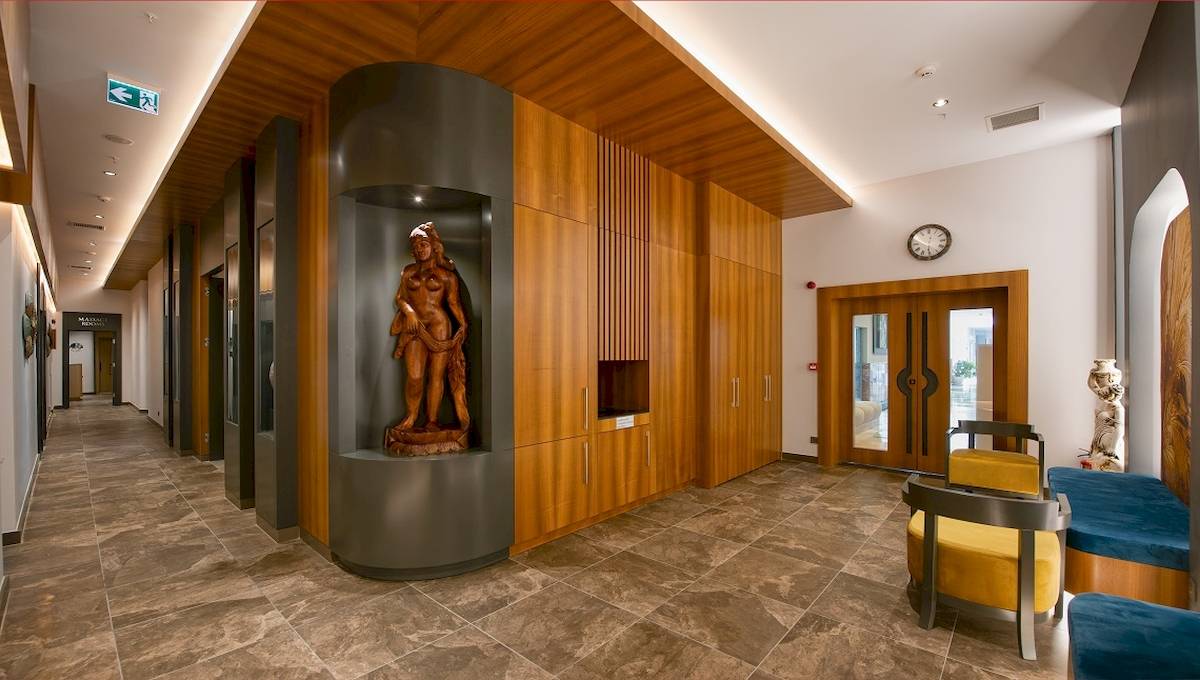 Innenbereich des Novum Garden Side Hotel mit einer Statue und Holzmöbeln.
