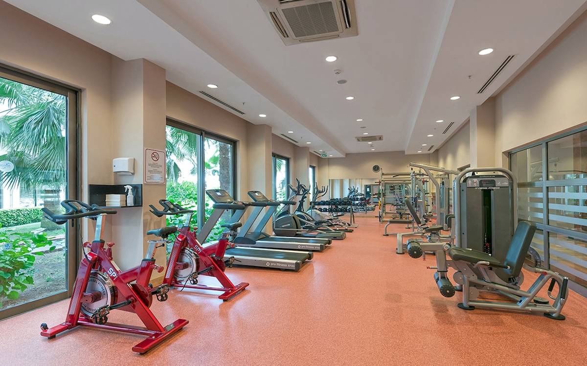 Fitnesscenter im Novum Garden Side Hotel mit mehreren Laufbändern und Fitnessgeräten.