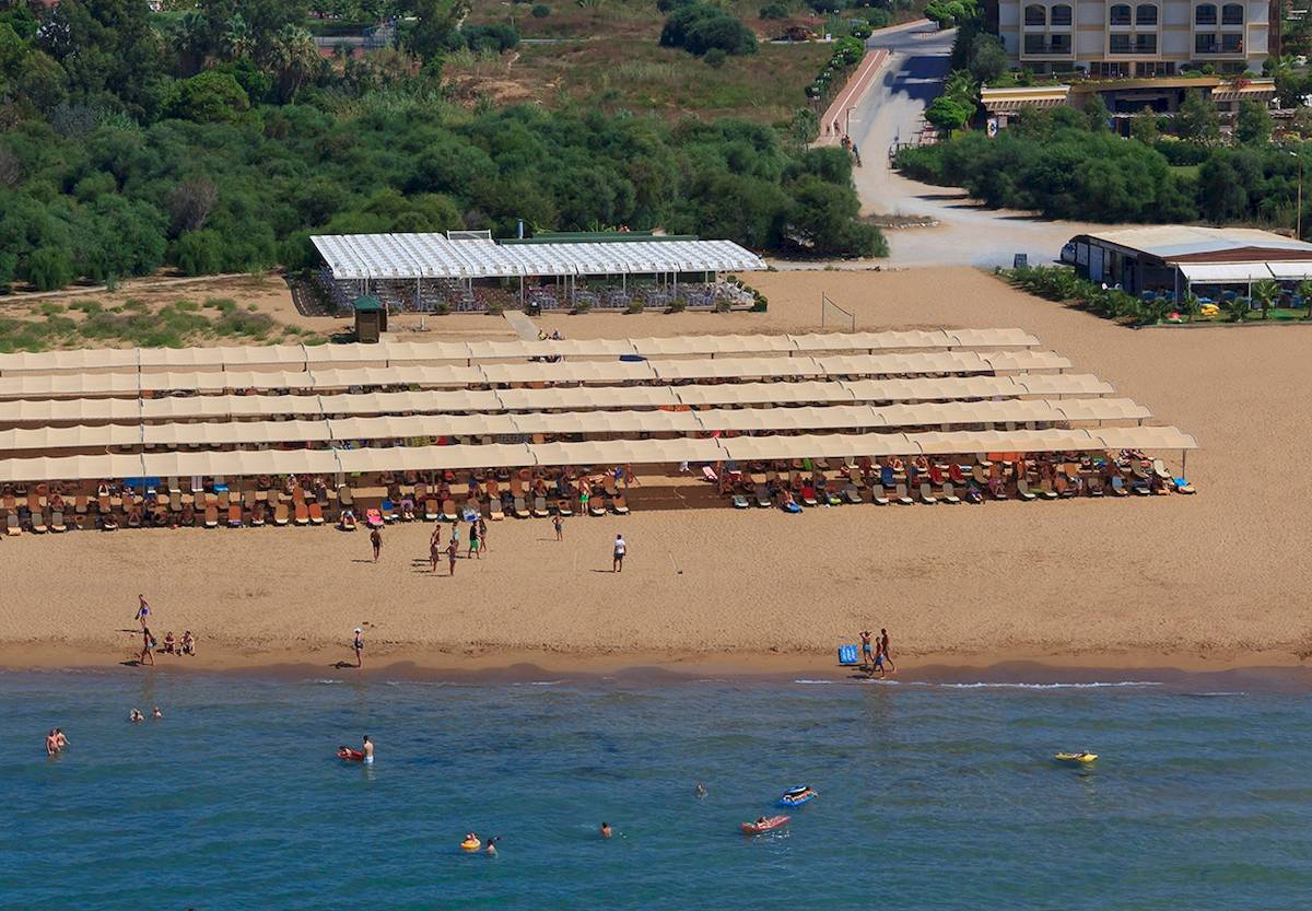Luftaufnahme des Novum Garden Side Hotels mit vielen Gästen am Strand und im Wasser.