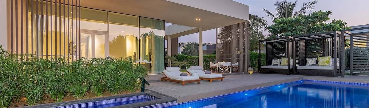 Außenbereich des Oberoi Beach Resort Al Zorah mit Swimmingpool und Lounges