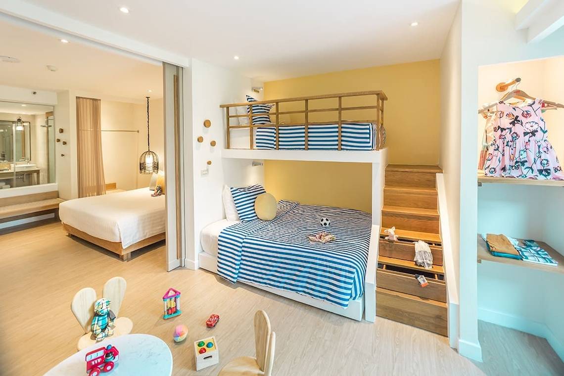 Ein Kinderzimmer im Bandara Resort & Spa, Samui mit zwei Etagenbetten, Spielzeug und einer begehbaren Garderobe.