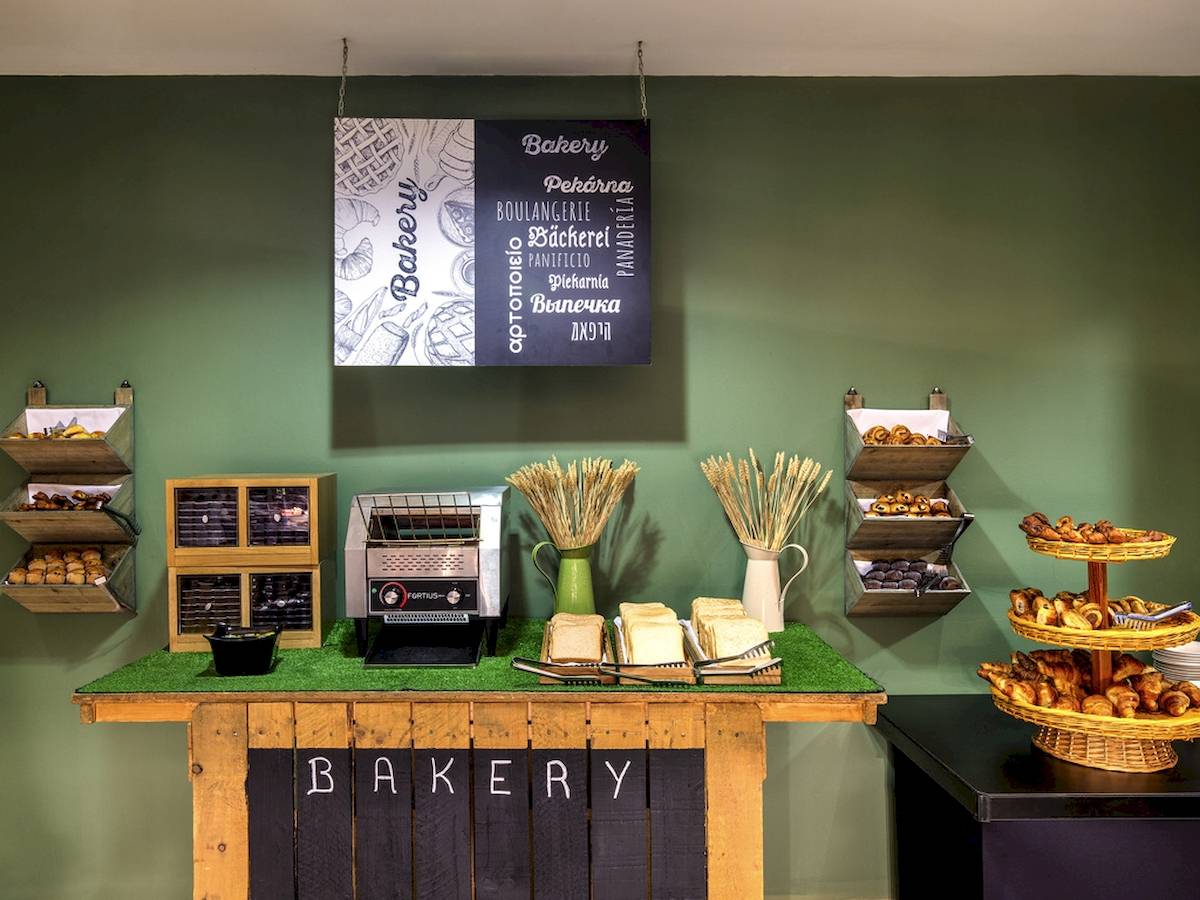 Hotelbäckertisch mit Gebäck und Toaster auf grüner Tischplatte