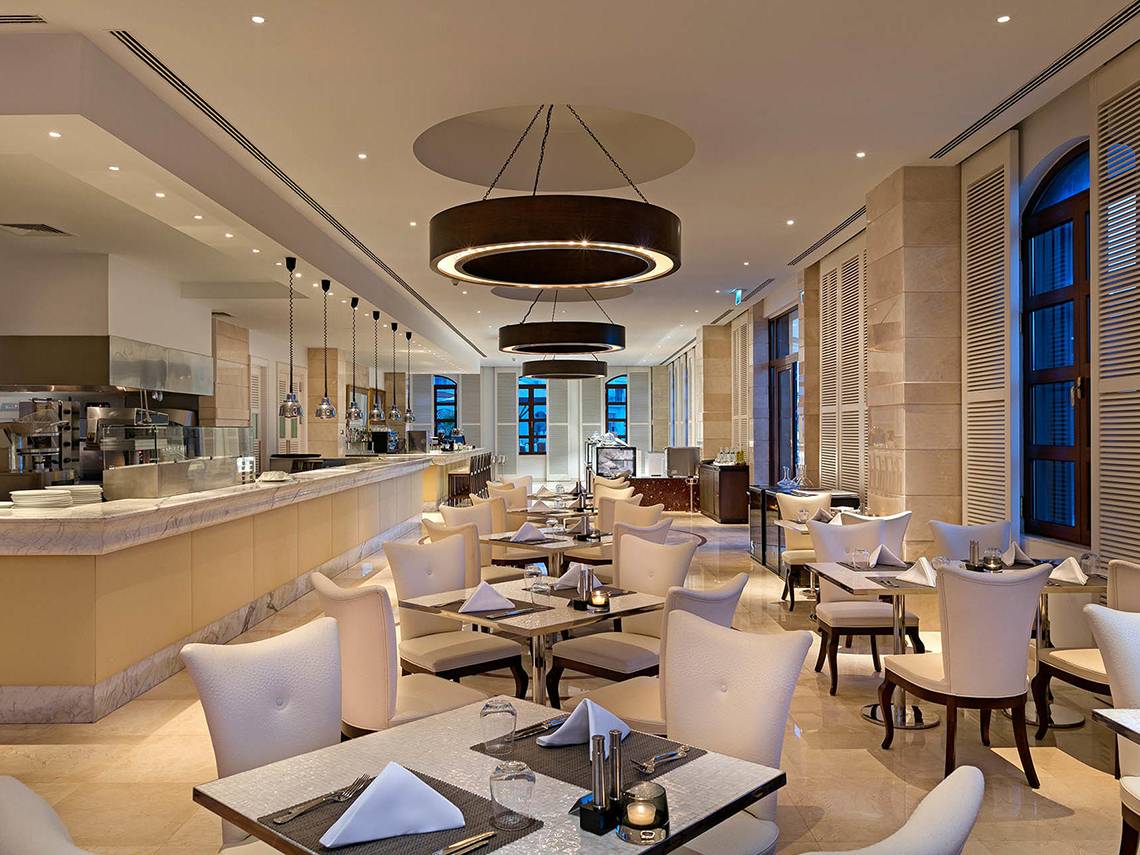 Innenansicht des Restaurants im Titanic Mardan Palace mit weißen Tischen und Stühlen.