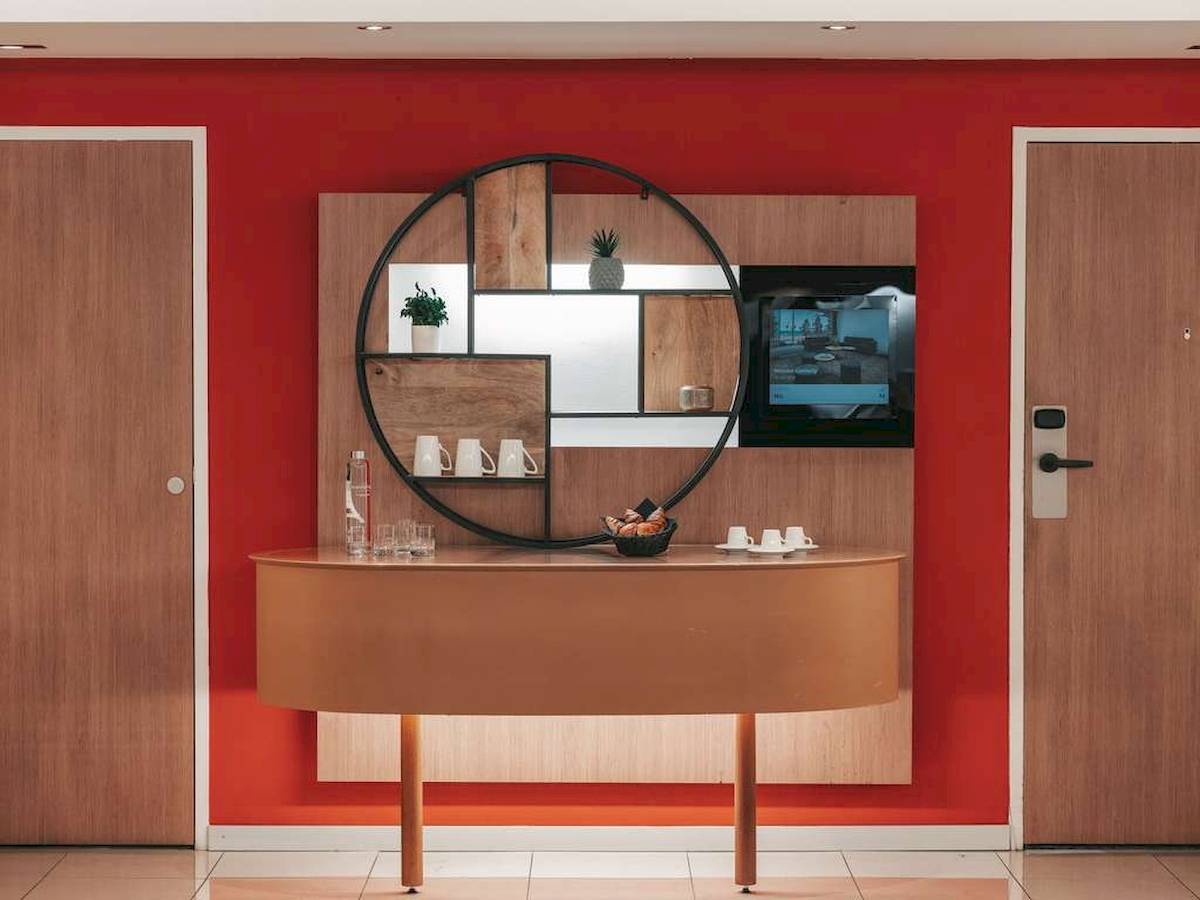 Einrichtung eines Zimmers im Novotel Paris Tour Eiffel mit rotem Wand, modernem Schreibtisch und Deko.