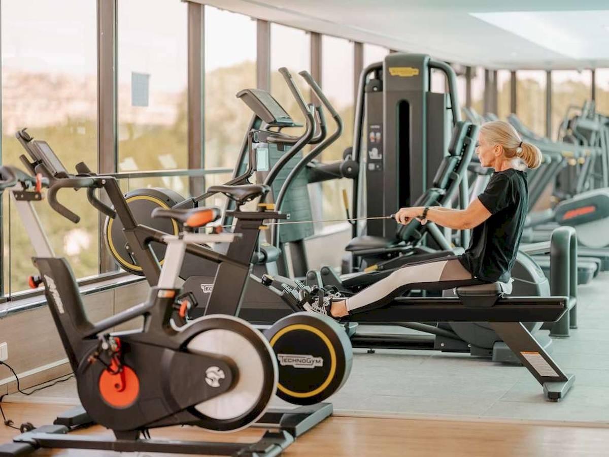 Eine Frau trainiert auf einem Rudergerät im Fitnessraum des Novotel Paris Tour Eiffel.