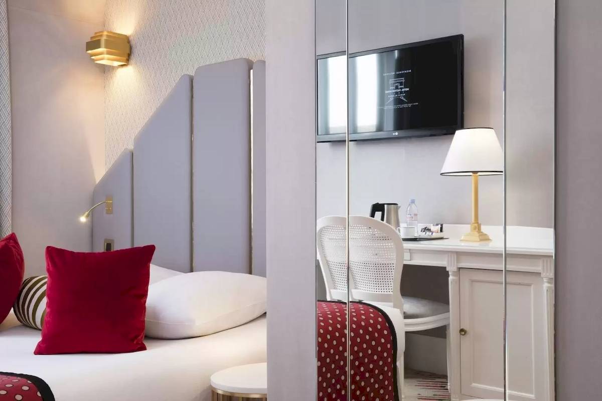 Ein modernes Hotelzimmer mit einem Bett, Dekor und Möbeln von Victor Hugo Paris Kléber.