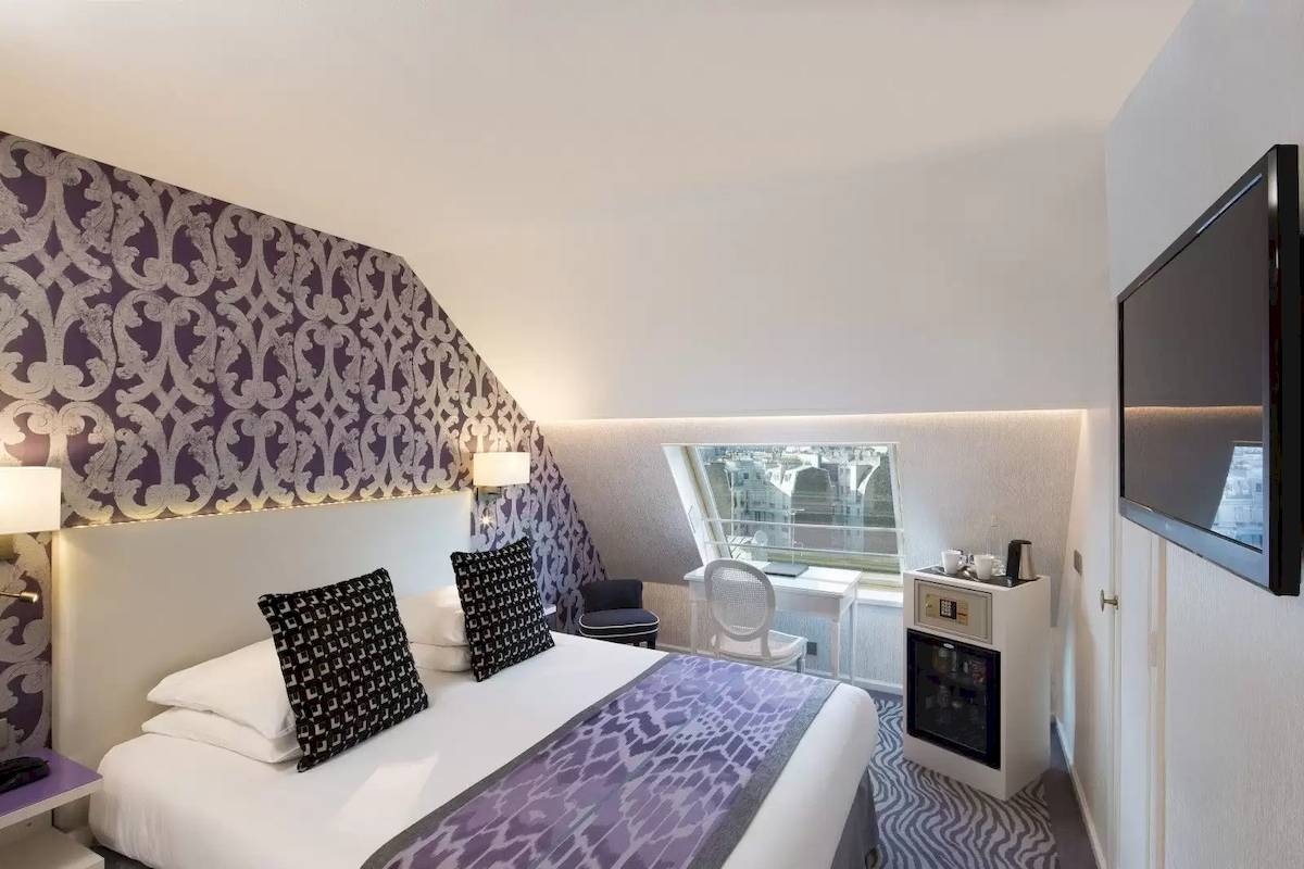 Hotelzimmer im Victor Hugo Paris Kléber mit Bett, Fernseher, Schreibtisch und Fenster
