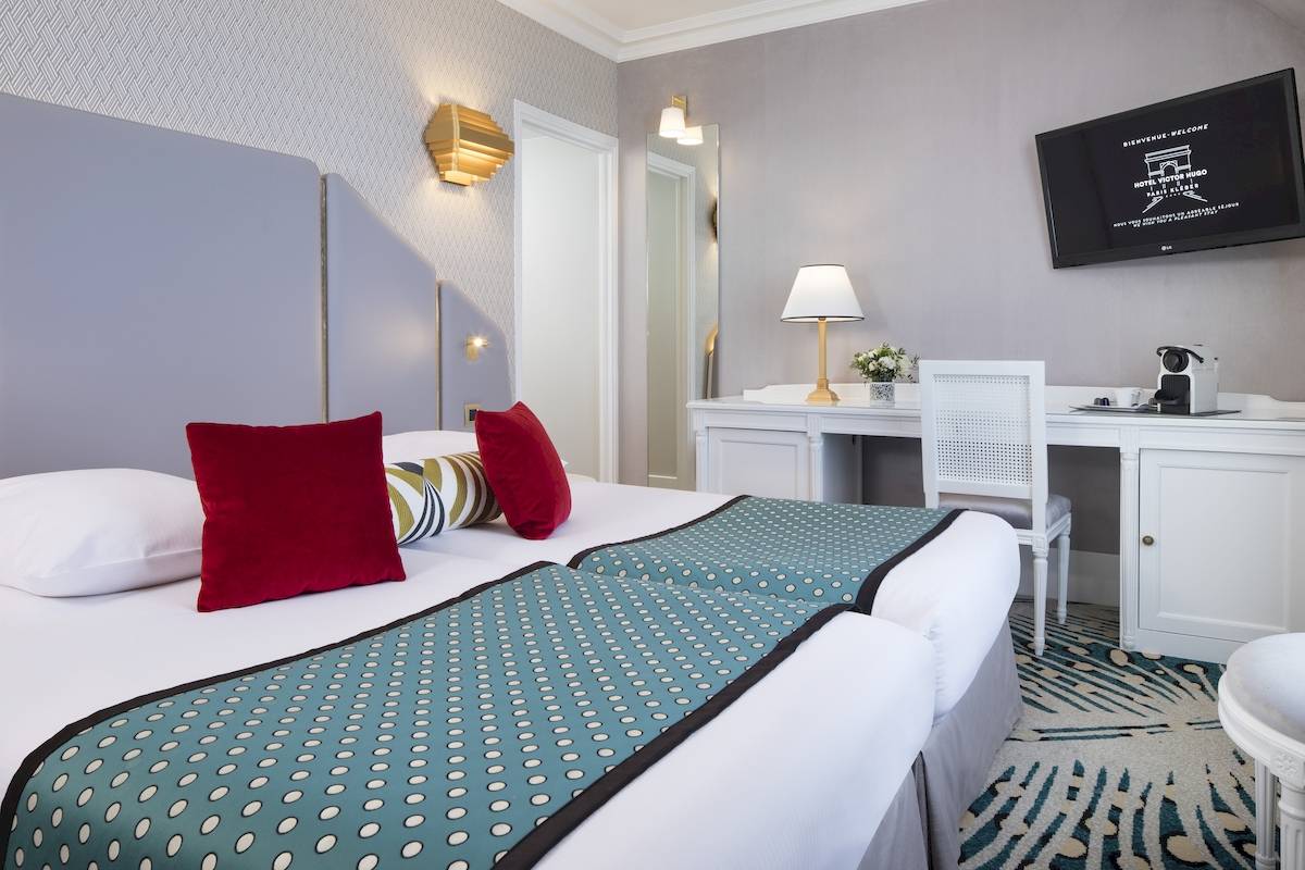 Doppelbettzimmer im Hotel Victor Hugo Paris Kléber mit modernen Möbeln und Dekor.