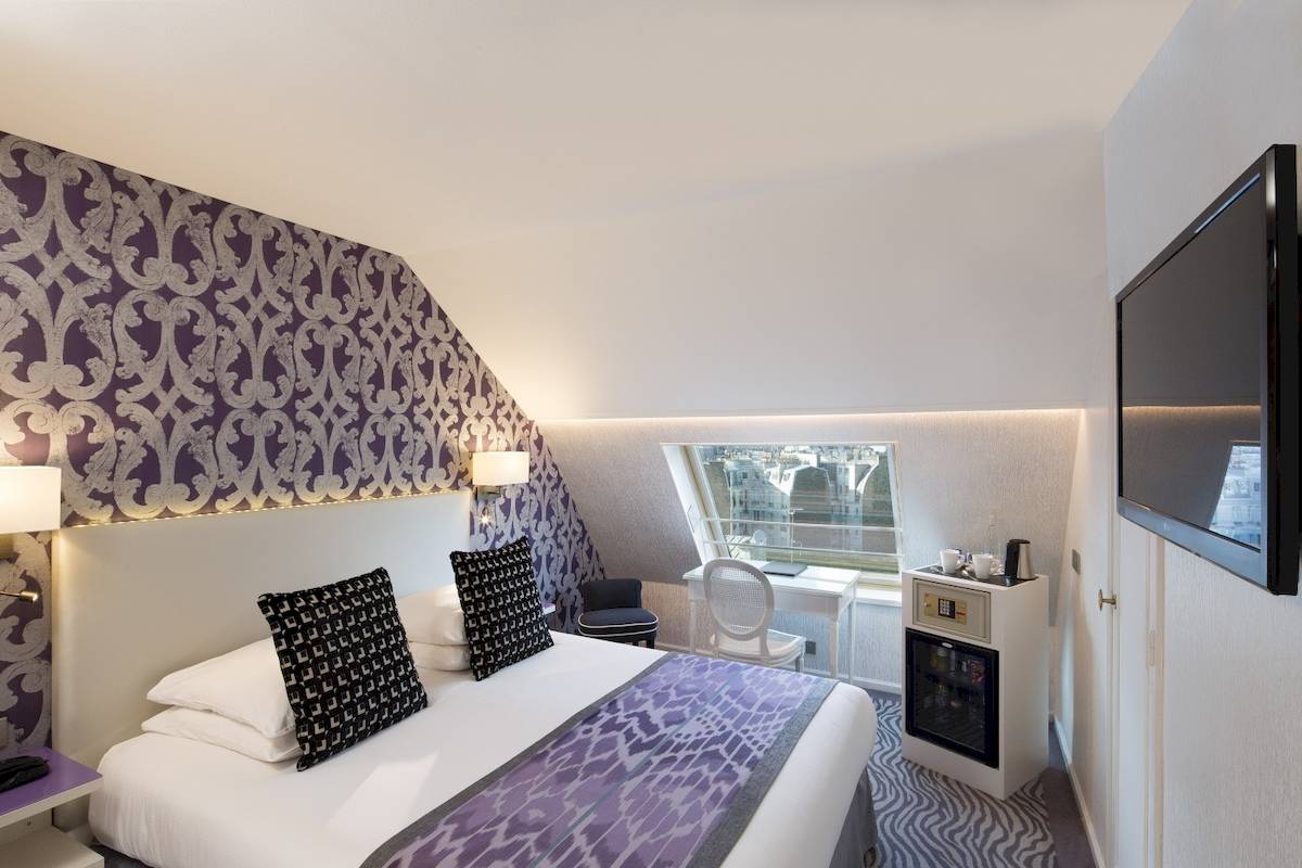 Hotelzimmer des Victor Hugo Paris Kléber mit Bett, Nachttisch, Fernseher und Schreibtisch