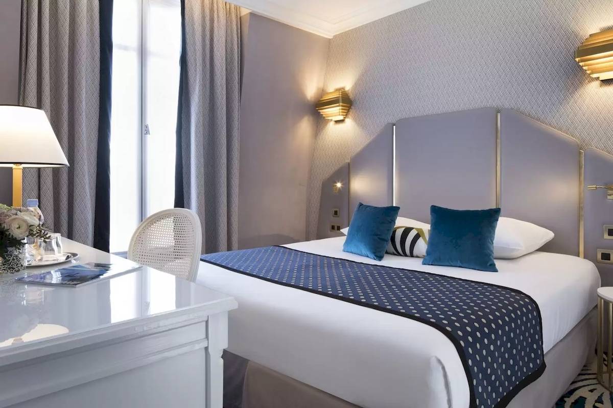 Elegant Hotelzimmer im Victor Hugo Paris Kléber mit einem Bett, Dekor und Möbeln.